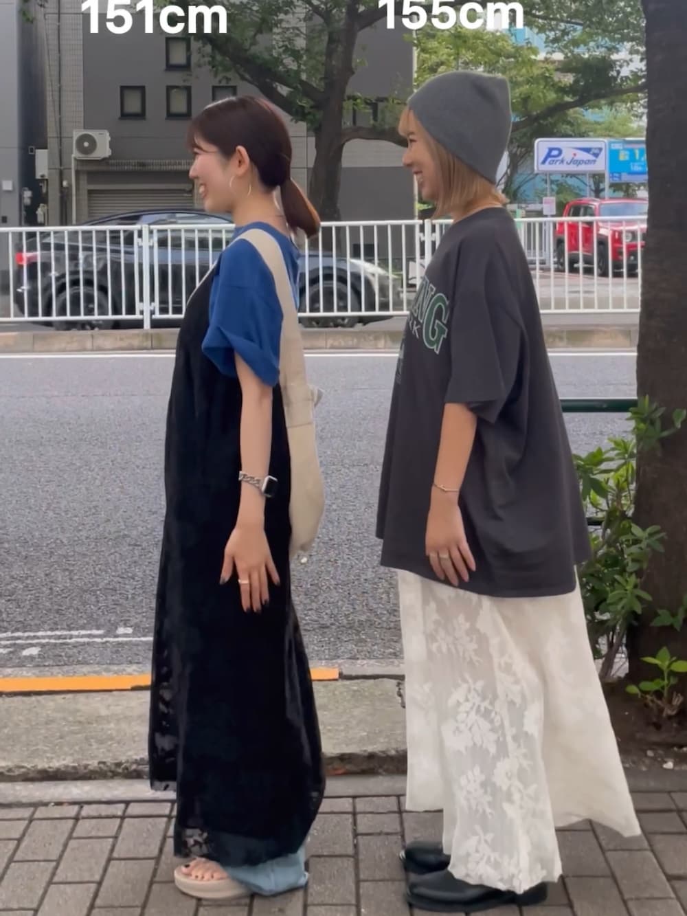 ブラック系のワンピース、ブルー系のデニムパンツ、ブルー系のショルダーバッグを着用したレディースの夏コーディネートの2枚目の写真