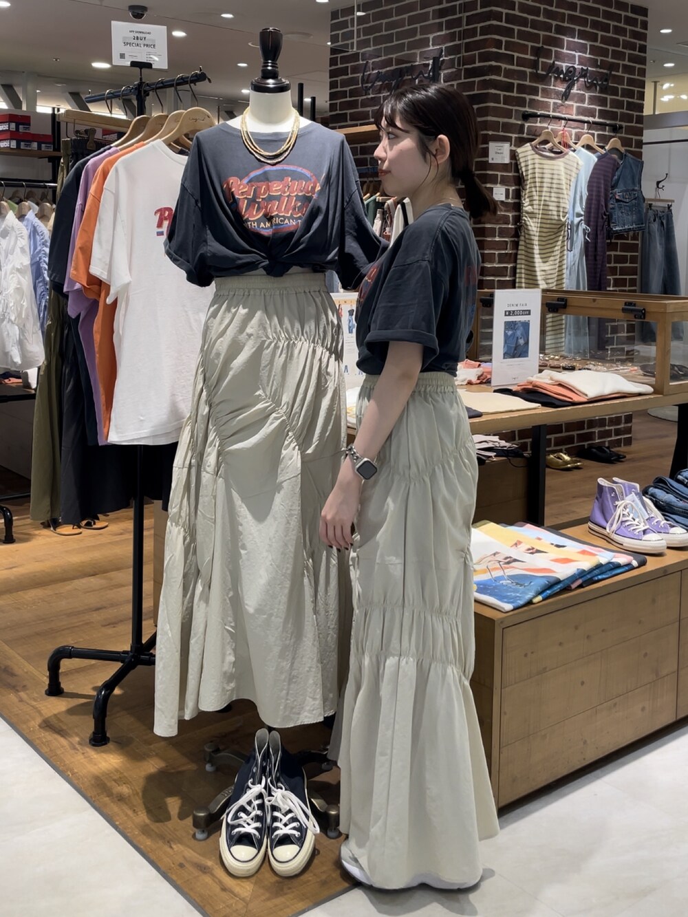 グレー系のTシャツ/カットソー、ホワイト系のスカートを着用したレディースの春コーディネートの2枚目の写真