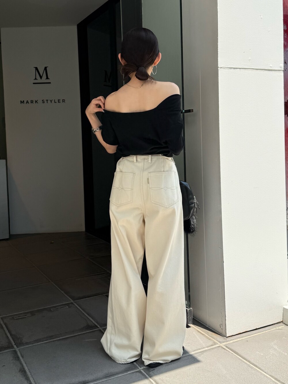 ブラック系のTシャツ/カットソー、ブラック系のサンダル、ブラック系のハンドバッグを着用したレディースの夏コーディネートの6枚目の写真