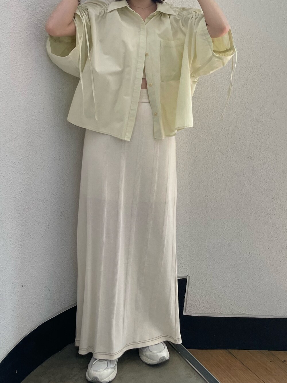 イエロー系のシャツ/ブラウス、ホワイト系のキャミソール、ホワイト系のスカートを着用したレディースの春コーディネートの7枚目の写真