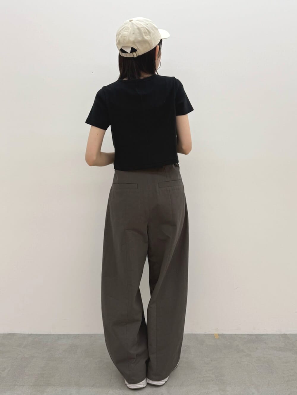 ブラック系のTシャツ/カットソー、グレー系のチノパンツ、ホワイト系のキャップを着用したレディースの春コーディネートの4枚目の写真