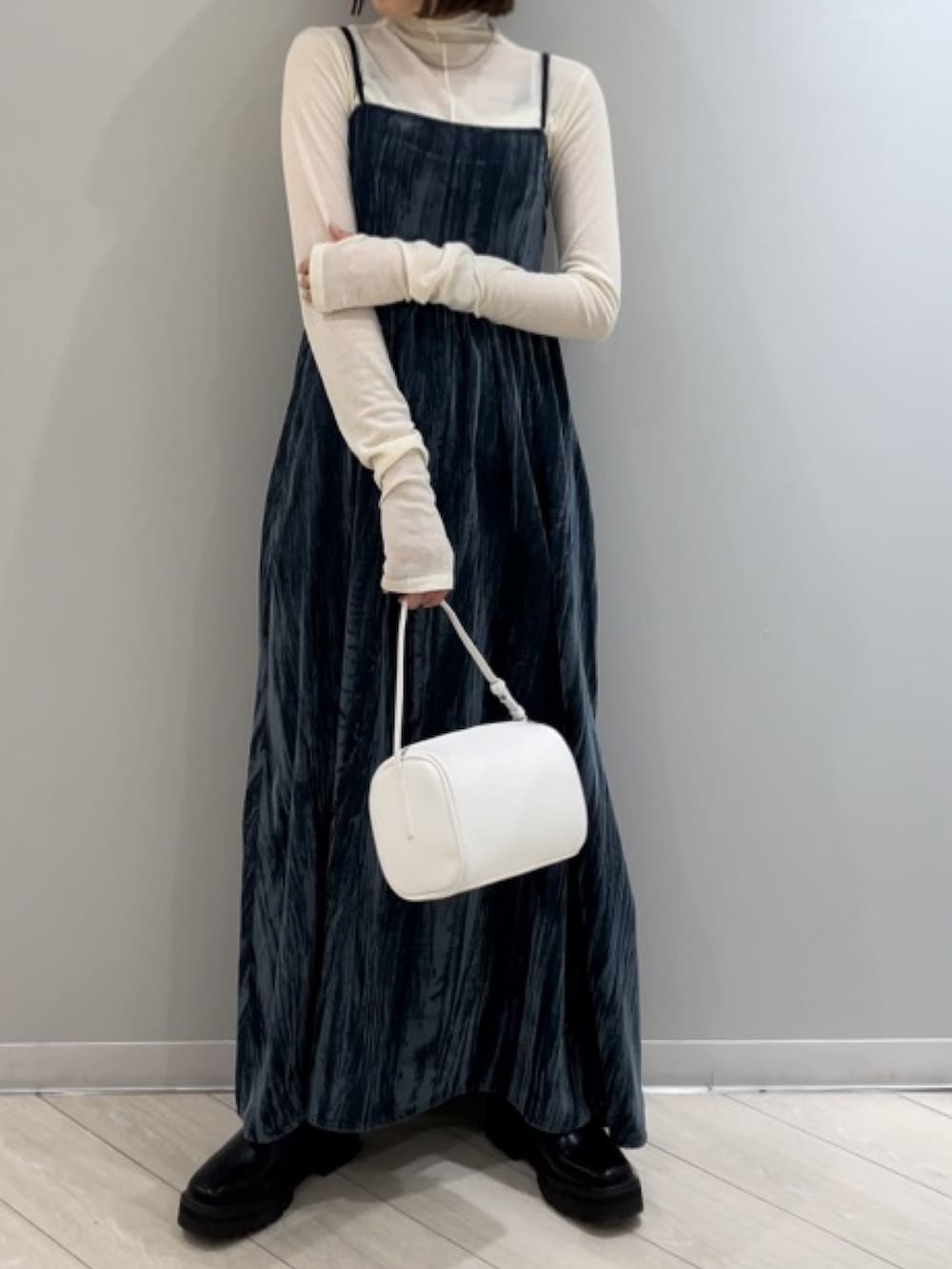 ホワイト系のハンドバッグ、ホワイト系のTシャツ/カットソー、ブルー系のワンピースを着用したレディースの冬コーディネートの3枚目の写真