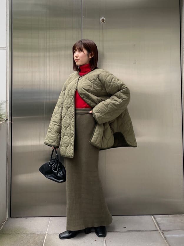 ブラック系のブーツ、グリーン系のブルゾン、レッド系のニット/セーターを着用したレディースの秋コーディネートの6枚目の写真