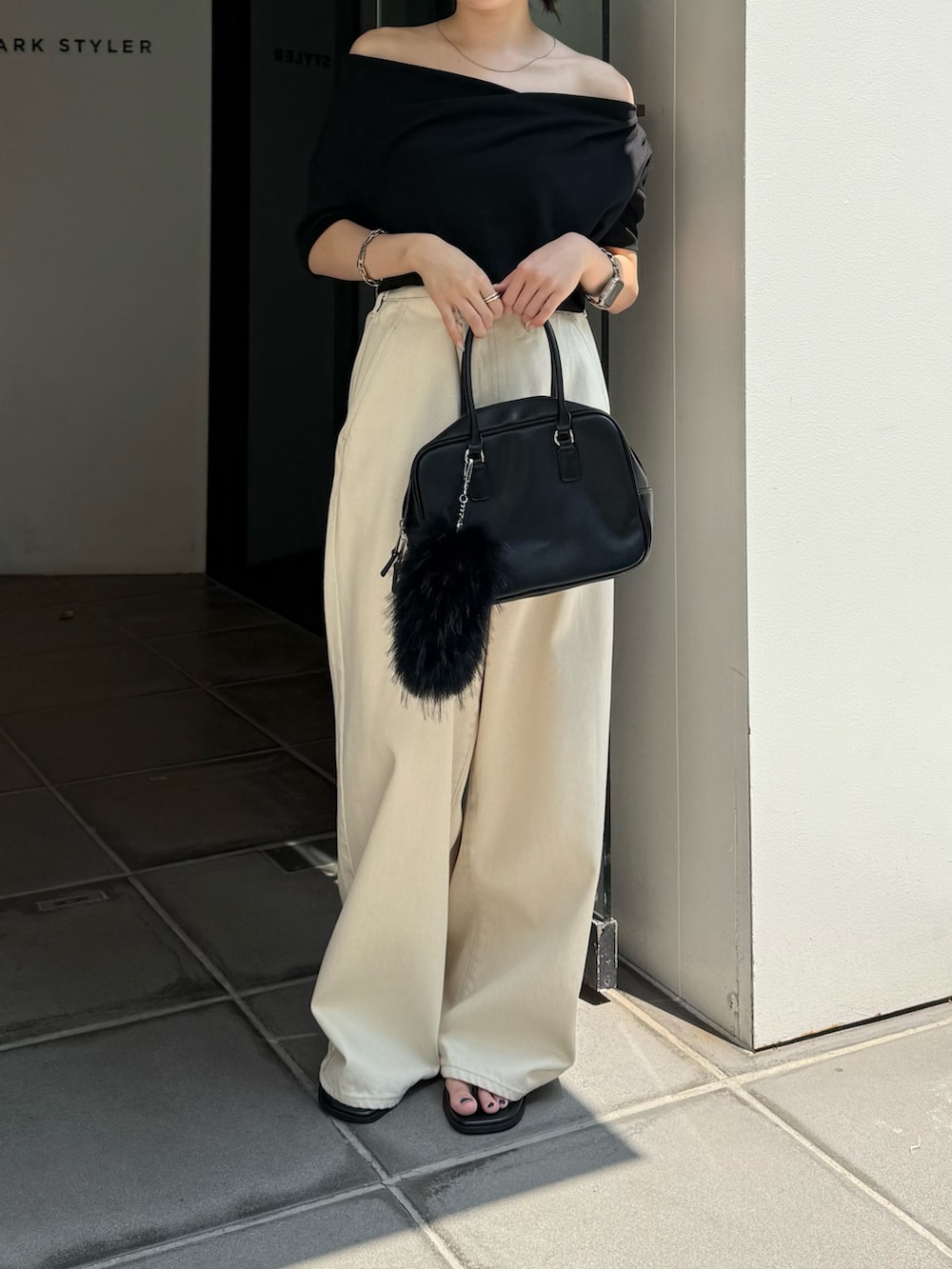 ブラック系のTシャツ/カットソー、ブラック系のサンダル、ブラック系のハンドバッグを着用したレディースの夏コーディネートの7枚目の写真