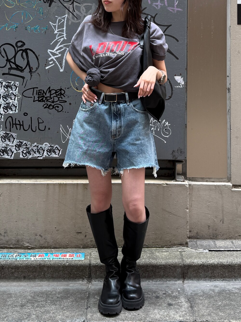 ブルー系のデニムパンツ、グレー系のTシャツ/カットソー、ブラック系のハンドバッグを着用したレディースの春コーディネートの2枚目の写真