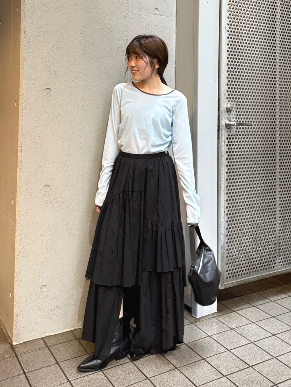 ブラック系のスカート、ブラック系のブーツを着用したレディースの夏コーディネートの2枚目の写真