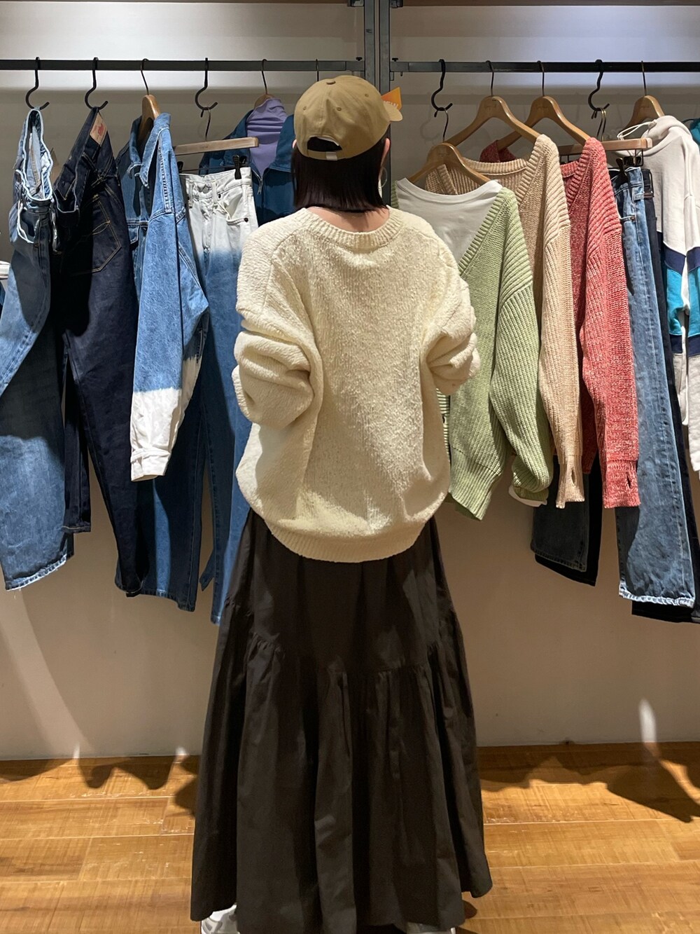 グレー系のスカート、ホワイト系のニット/セーター、ベージュ系のキャップを着用したレディースの冬コーディネートの4枚目の写真