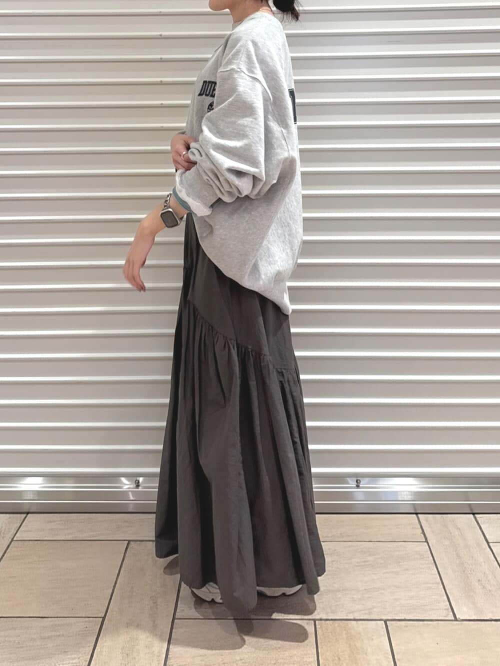 グレー系のスカート、グレー系のスウェットを着用したレディースの秋コーディネートの3枚目の写真