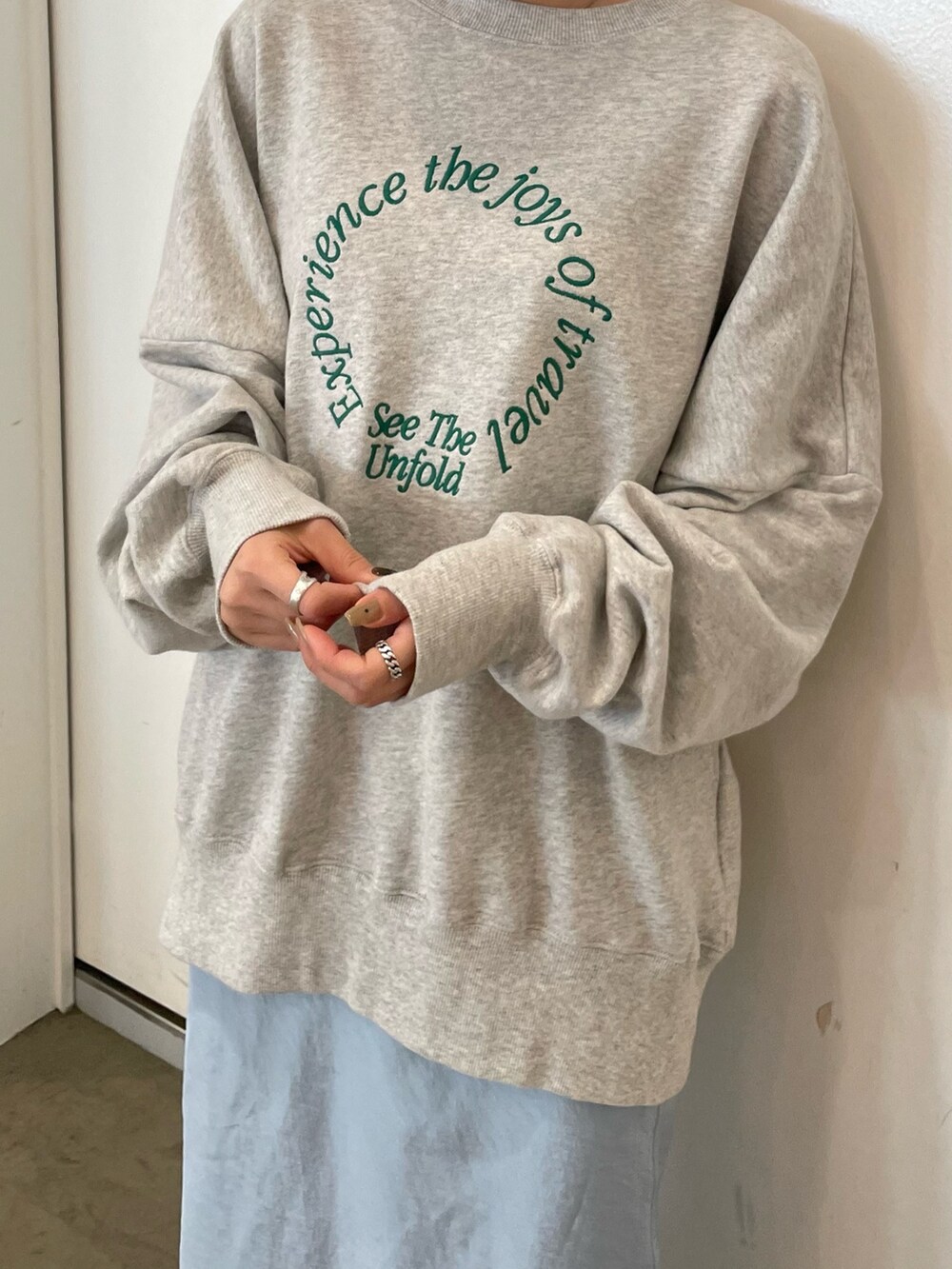 グレー系のスウェット、ブルー系のスカート、ブラック系のサンダルを着用したレディースの冬コーディネートの4枚目の写真