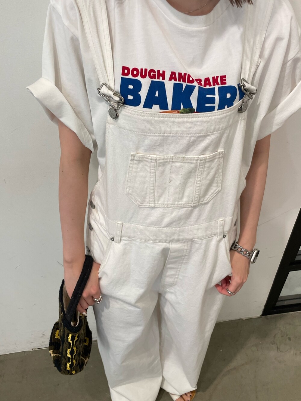ホワイト系のサンダル、ホワイト系のTシャツ/カットソー、ブラウン系のハンドバッグを着用したレディースの春コーディネートの8枚目の写真