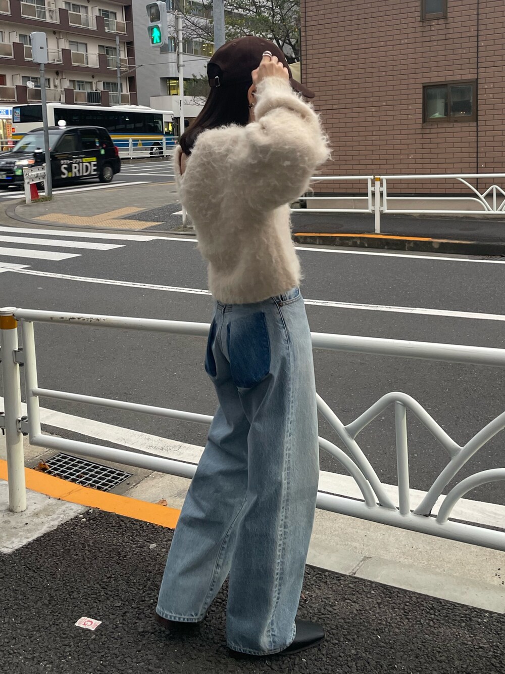 ブラック系のブーツ、ブルー系のデニムパンツ、ホワイト系のニット/セーターを着用したレディースの秋コーディネートの4枚目の写真