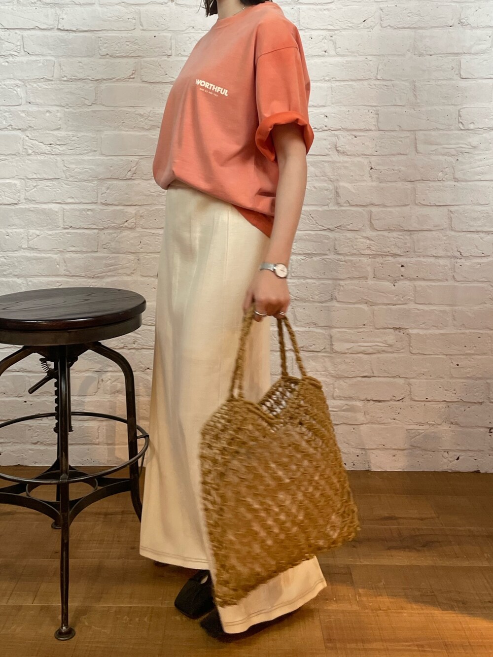 ホワイト系のスカート、イエロー系のハンドバッグ、ブラック系のパンプスを着用したレディースの春コーディネートの6枚目の写真