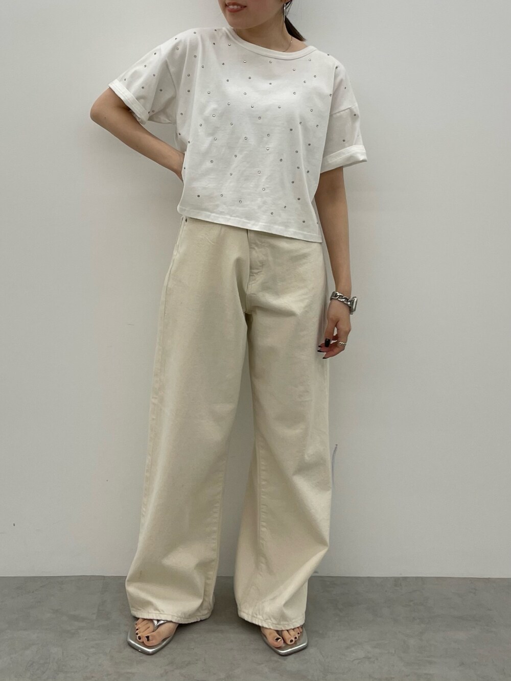 ホワイト系のデニムパンツ、シルバー系のサンダル、ホワイト系のTシャツ/カットソーを着用したレディースの春コーディネートの2枚目の写真