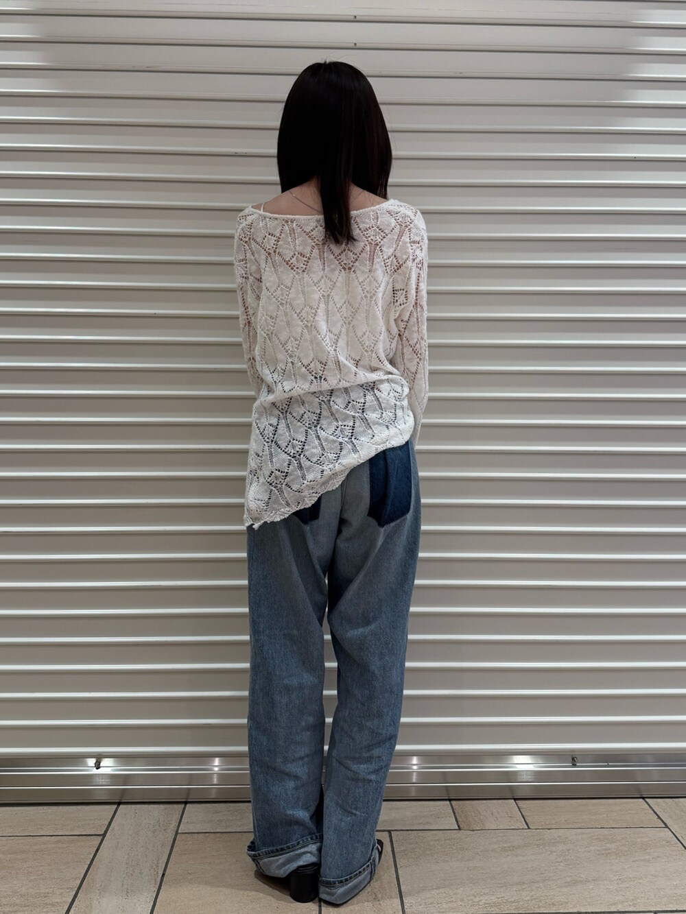 ブルー系のデニムパンツ、ホワイト系のニット/セーターを着用したレディースの夏コーディネートの3枚目の写真