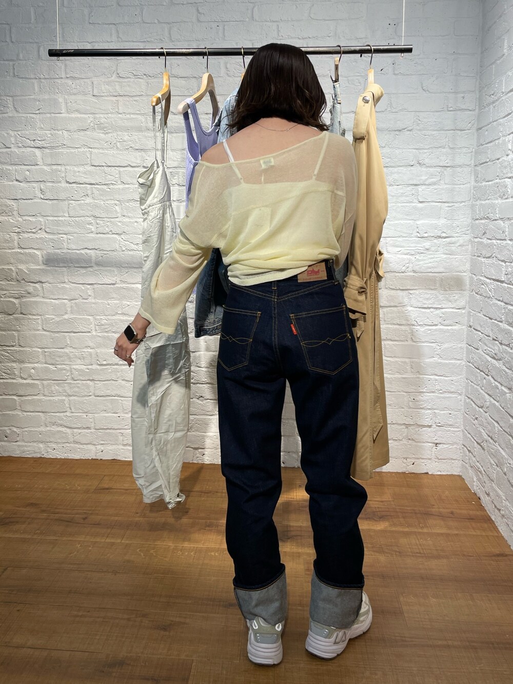 イエロー系のニット/セーター、ブルー系のデニムパンツを着用したレディースの春コーディネートの6枚目の写真