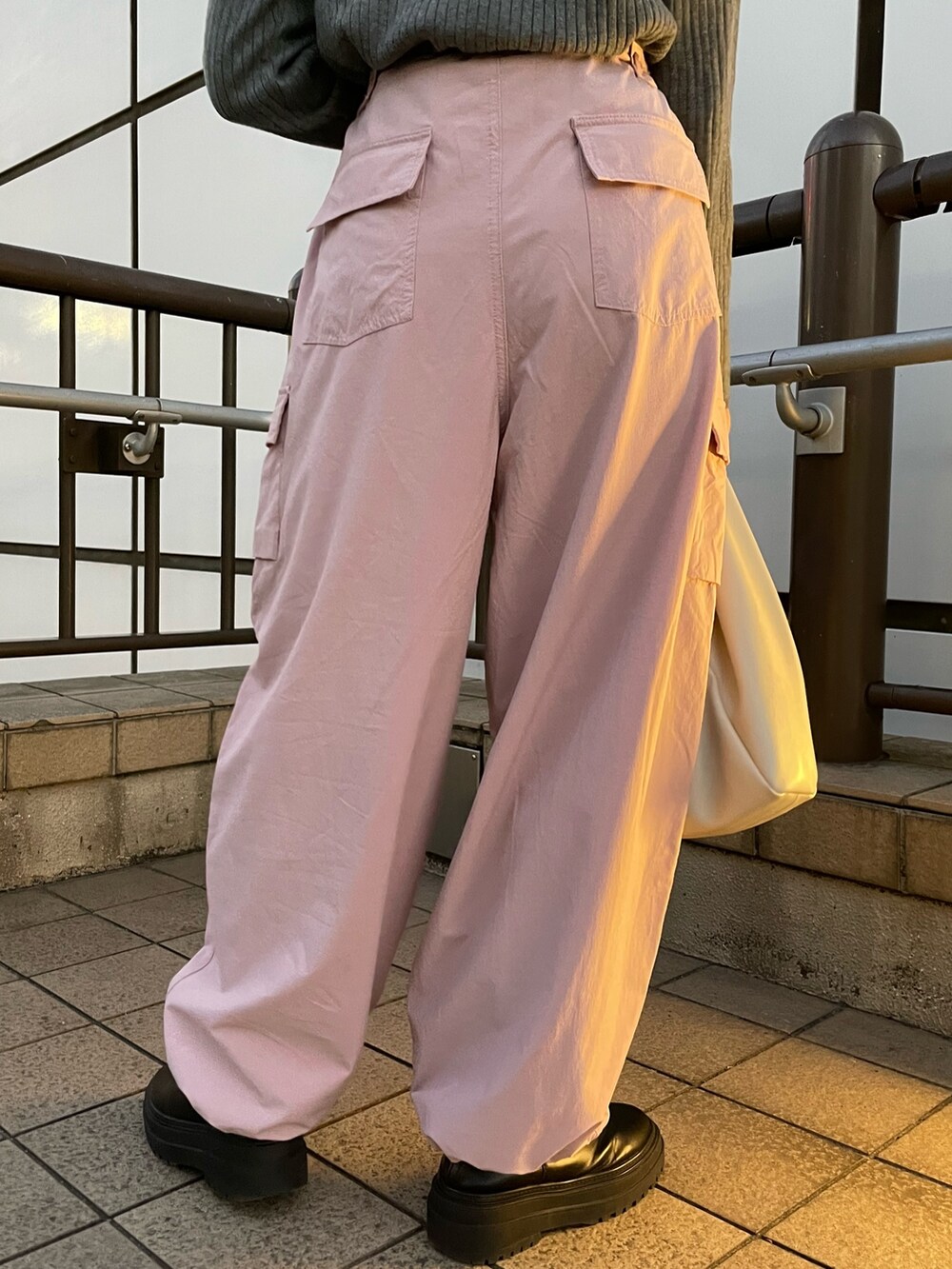 ピンク系のカーゴパンツ、ホワイト系のハンドバッグ、グレー系のニット/セーターを着用したレディースの冬コーディネートの8枚目の写真