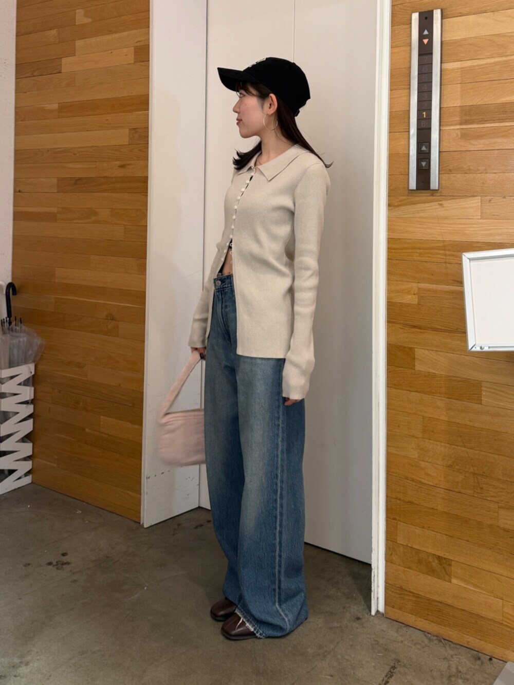 ブラウン系のブーツ、ブルー系のデニムパンツ、ピンク系のハンドバッグを着用したレディースの秋コーディネートの3枚目の写真