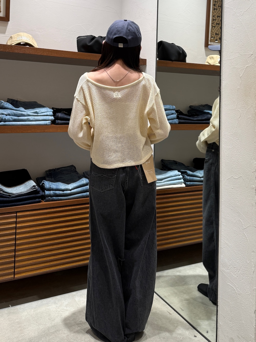 ブラック系のデニムパンツ、ブラック系のサンダル、ホワイト系のカーディガン/ボレロを着用したレディースの春コーディネートの4枚目の写真