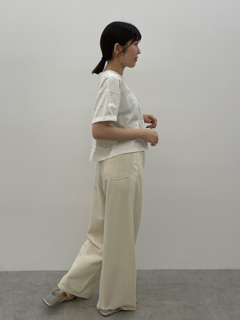 ホワイト系のデニムパンツ、シルバー系のサンダル、ホワイト系のTシャツ/カットソーを着用したレディースの春コーディネートの4枚目の写真