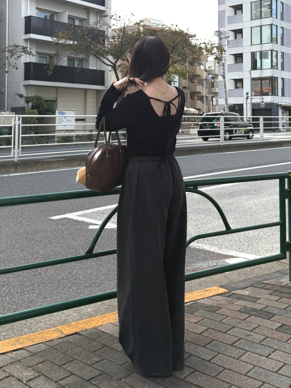 ブラウン系のハンドバッグ、グレー系のその他パンツ、ブラック系のTシャツ/カットソーを着用したレディースの秋コーディネートの3枚目の写真