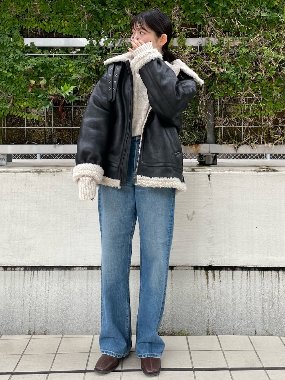 ブルー系のデニムパンツ、ブラウン系のブーツ、ホワイト系のニット/セーターを着用したレディースの秋コーディネートの2枚目の写真