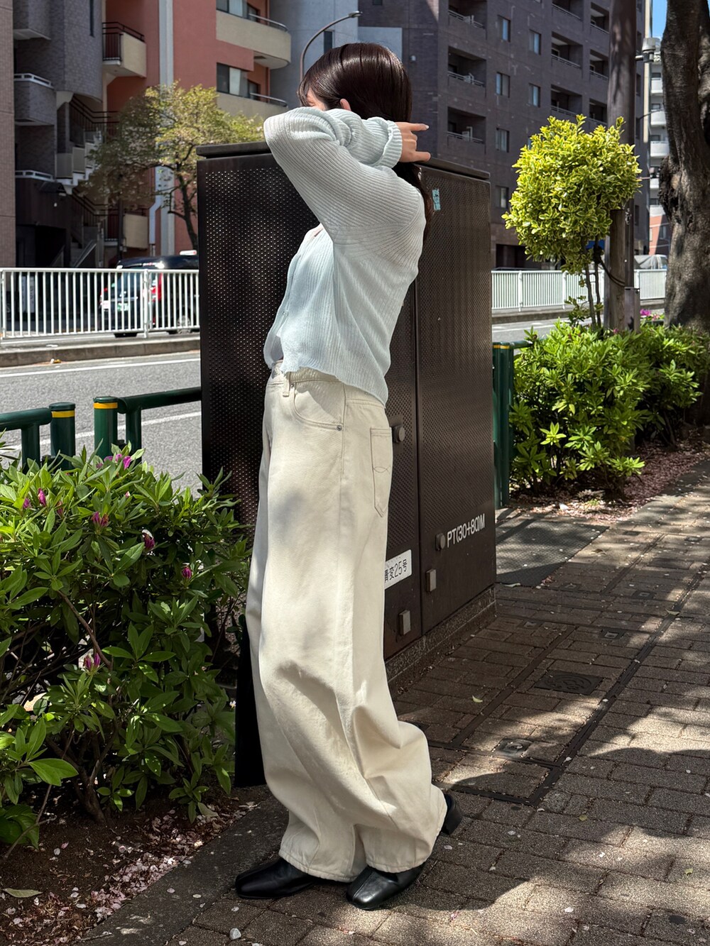 ブルー系のカーディガン/ボレロ、ホワイト系のデニムパンツ、ブラック系のハンドバッグを着用したレディースの春コーディネートの4枚目の写真