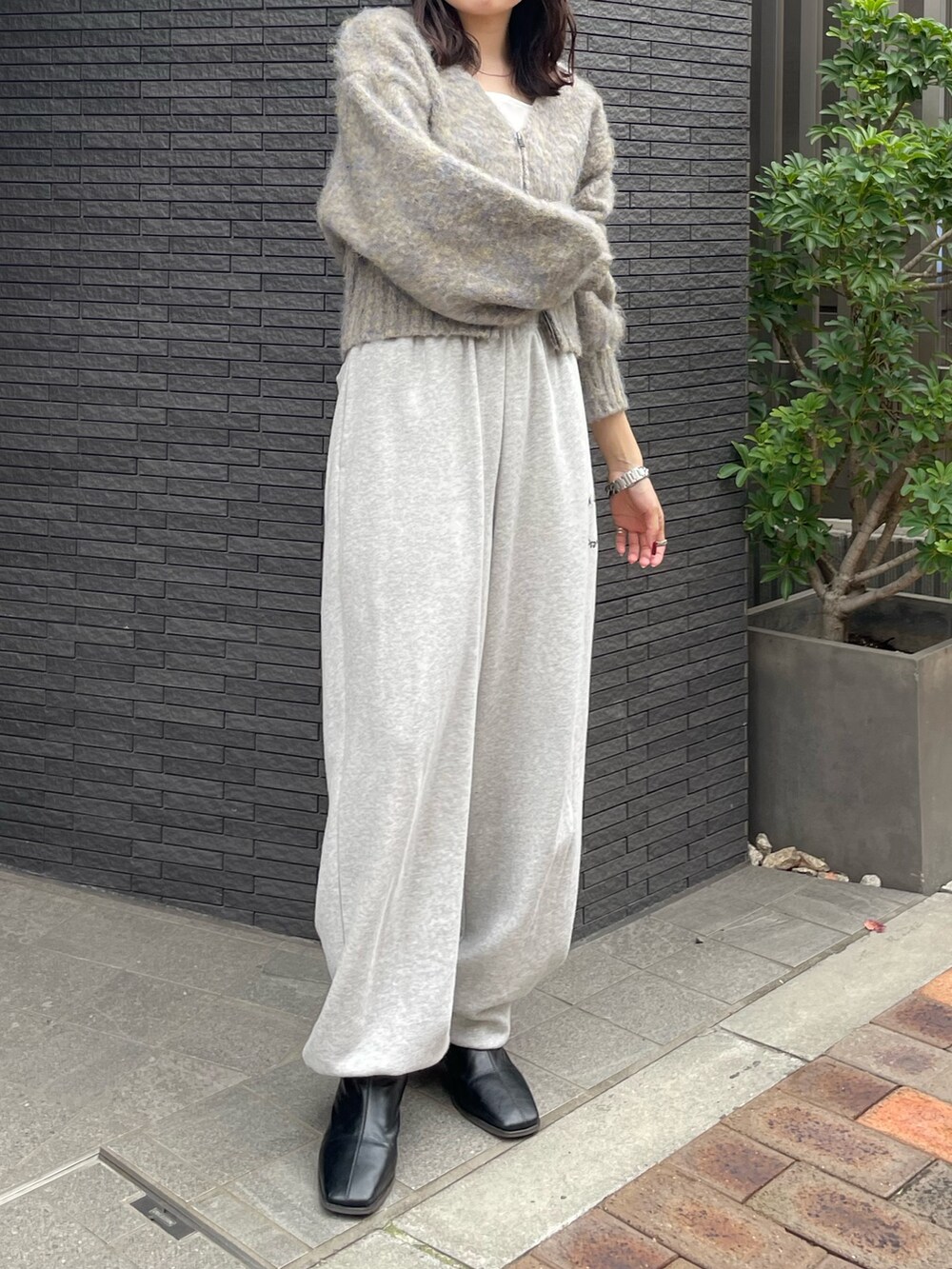グレー系のスウェットパンツ、ブラック系のブーツ、グレー系のカーディガン/ボレロを着用したレディースの冬コーディネートの3枚目の写真
