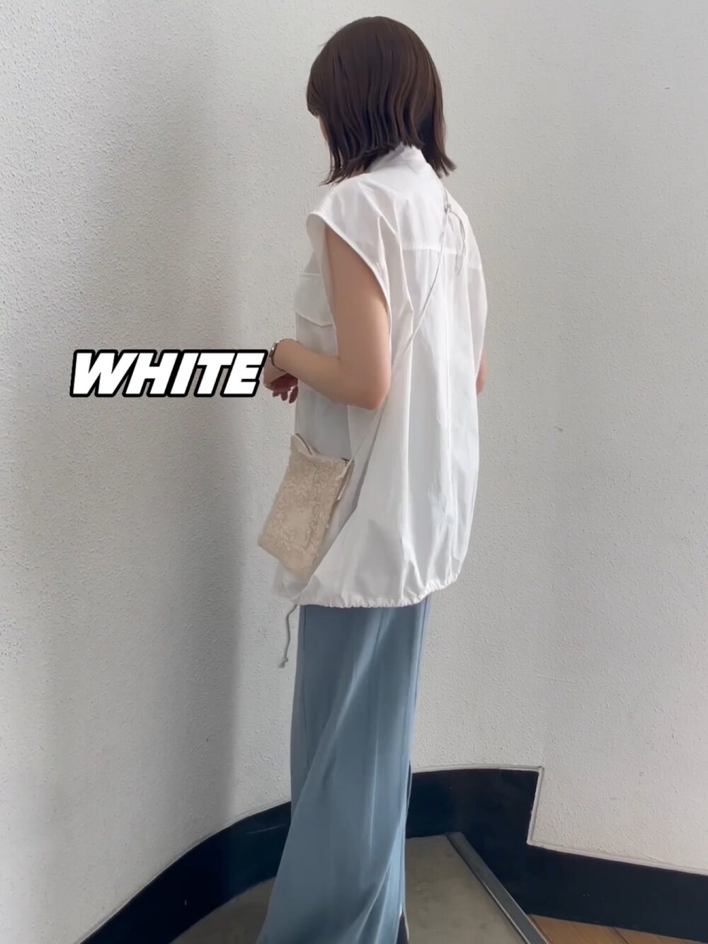 ホワイト系のショルダーバッグ、ホワイト系のキャミソール、ブルー系のスカートを着用したレディースの春コーディネートの2枚目の写真