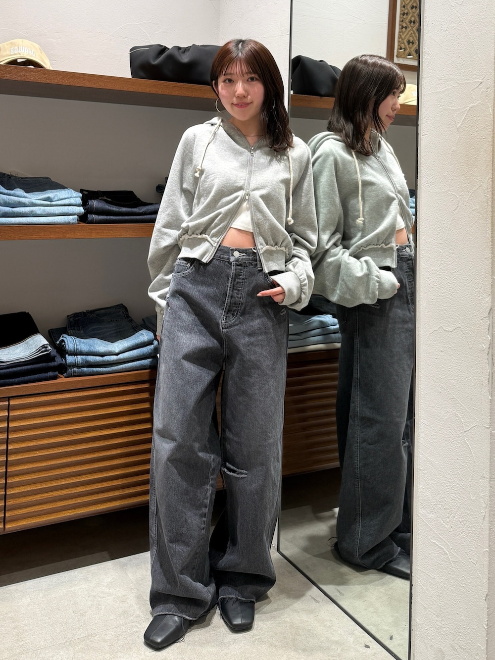 ブラック系のサンダル、グレー系のパーカー、ブラック系のデニムパンツを着用したレディースの春コーディネートの2枚目の写真