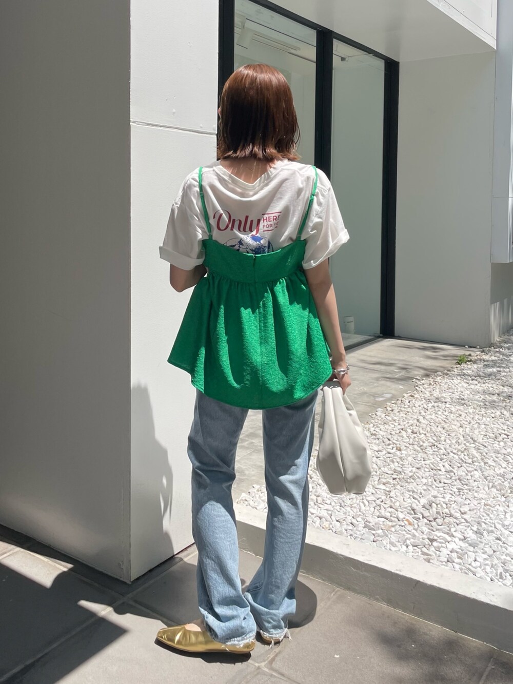 ホワイト系のハンドバッグ、ブルー系のデニムパンツ、グリーン系のシャツ/ブラウスを着用したレディースの春コーディネートの4枚目の写真