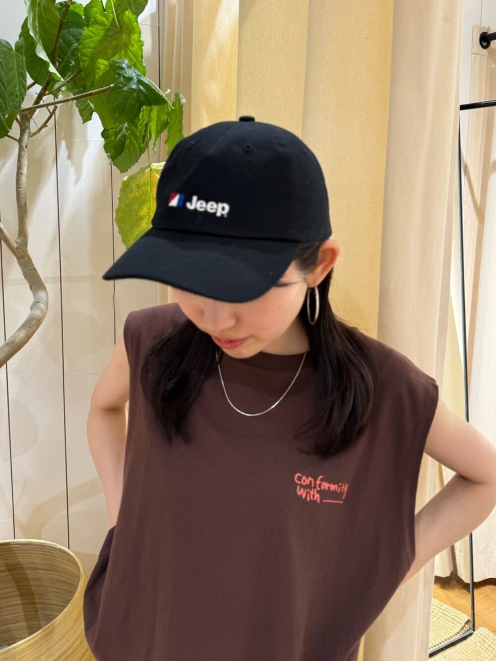 ブラウン系のタンクトップ、グレー系のスカート、ブラック系のキャップを着用したレディースの夏コーディネートの5枚目の写真
