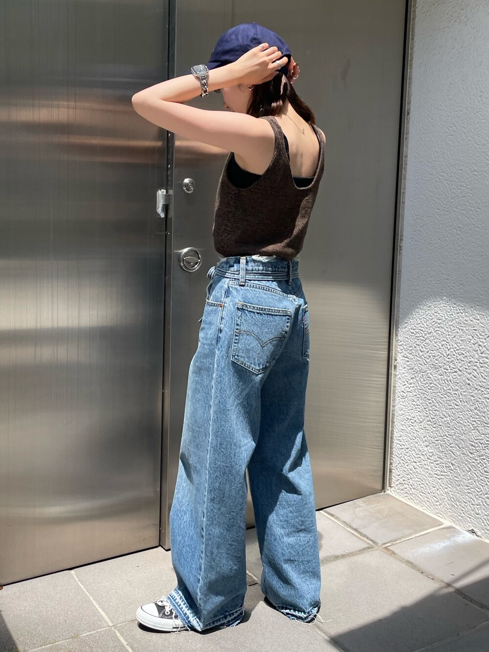 ブラウン系のベスト、ブルー系のデニムパンツ、ブルー系のキャップを着用したレディースの夏コーディネートの5枚目の写真