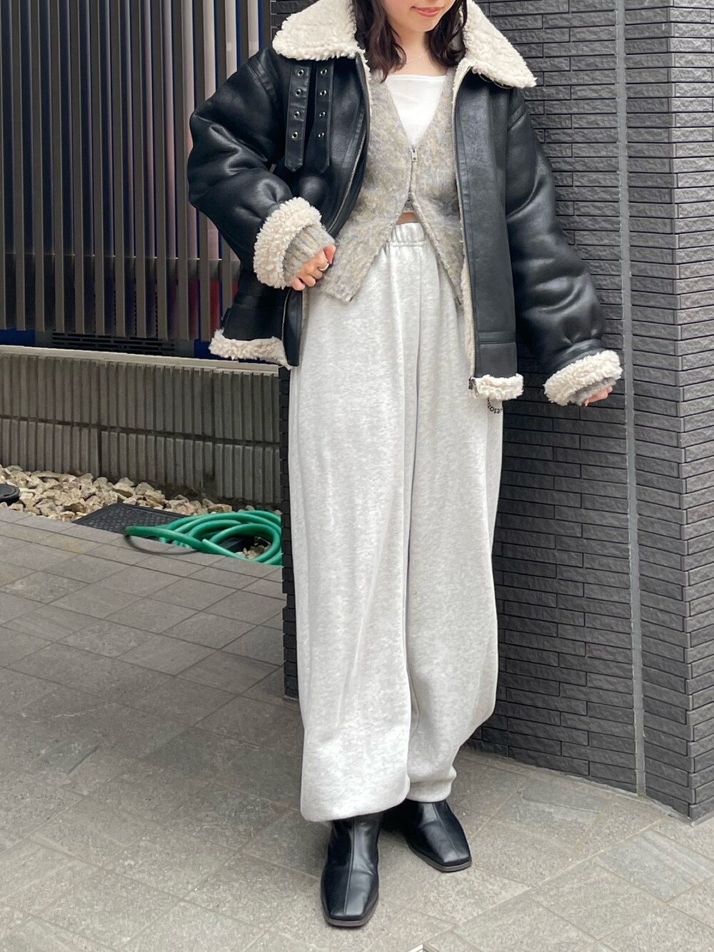 グレー系のスウェットパンツ、ブラック系のブーツ、グレー系のカーディガン/ボレロを着用したレディースの冬コーディネートの6枚目の写真