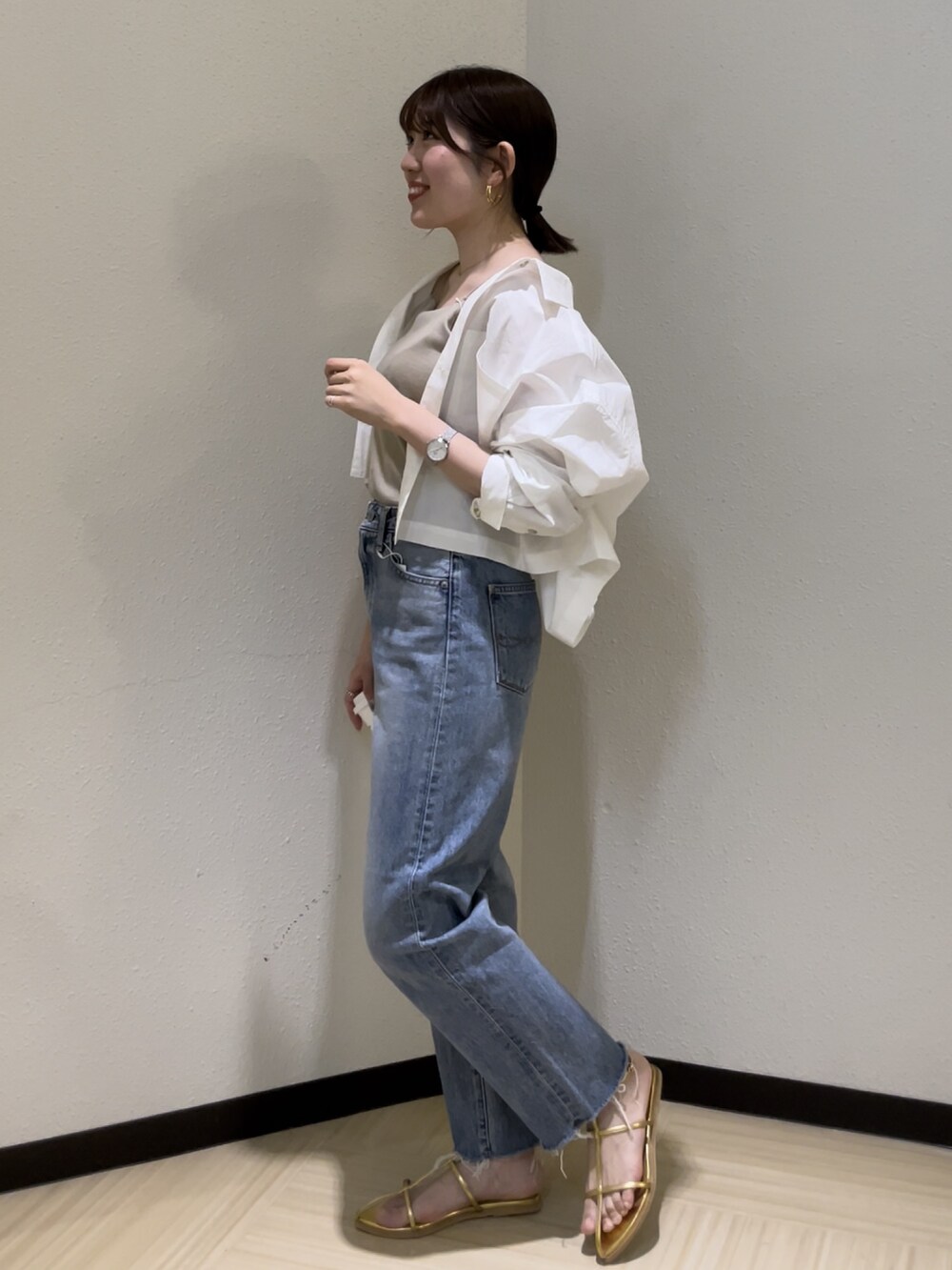 ブルー系のデニムパンツ、ベージュ系のキャミソール、ホワイト系のシャツ/ブラウスを着用したレディースの春コーディネートの7枚目の写真