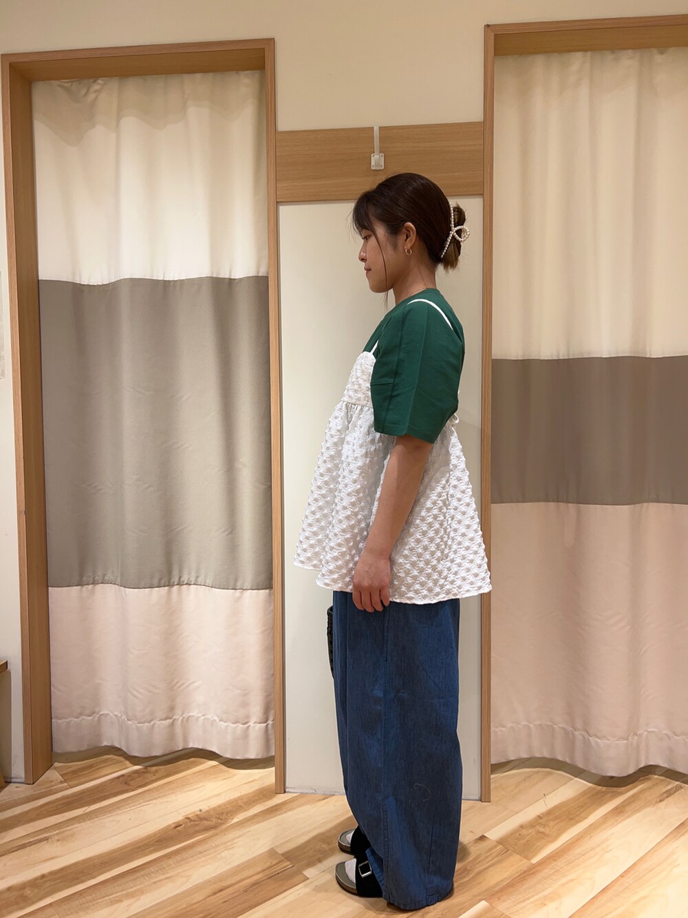 ブラック系のバッグ、ホワイト系のシャツ/ブラウス、ブルー系のデニムパンツを着用したレディースの春コーディネートの2枚目の写真