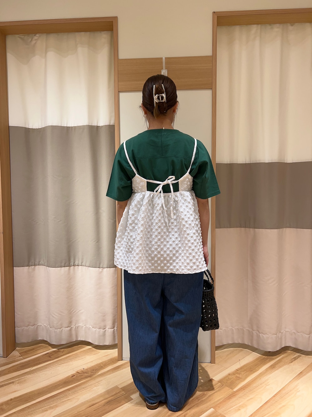 ブラック系のバッグ、ホワイト系のシャツ/ブラウス、ブルー系のデニムパンツを着用したレディースの春コーディネートの3枚目の写真