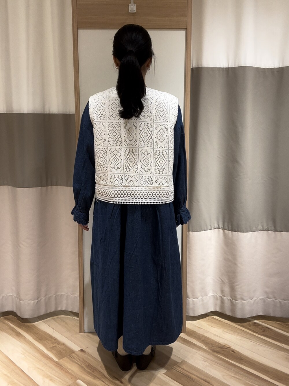 ブルー系のワンピース、ブラウン系のドレスシューズ、ホワイト系のベストを着用したレディースの夏コーディネートの3枚目の写真