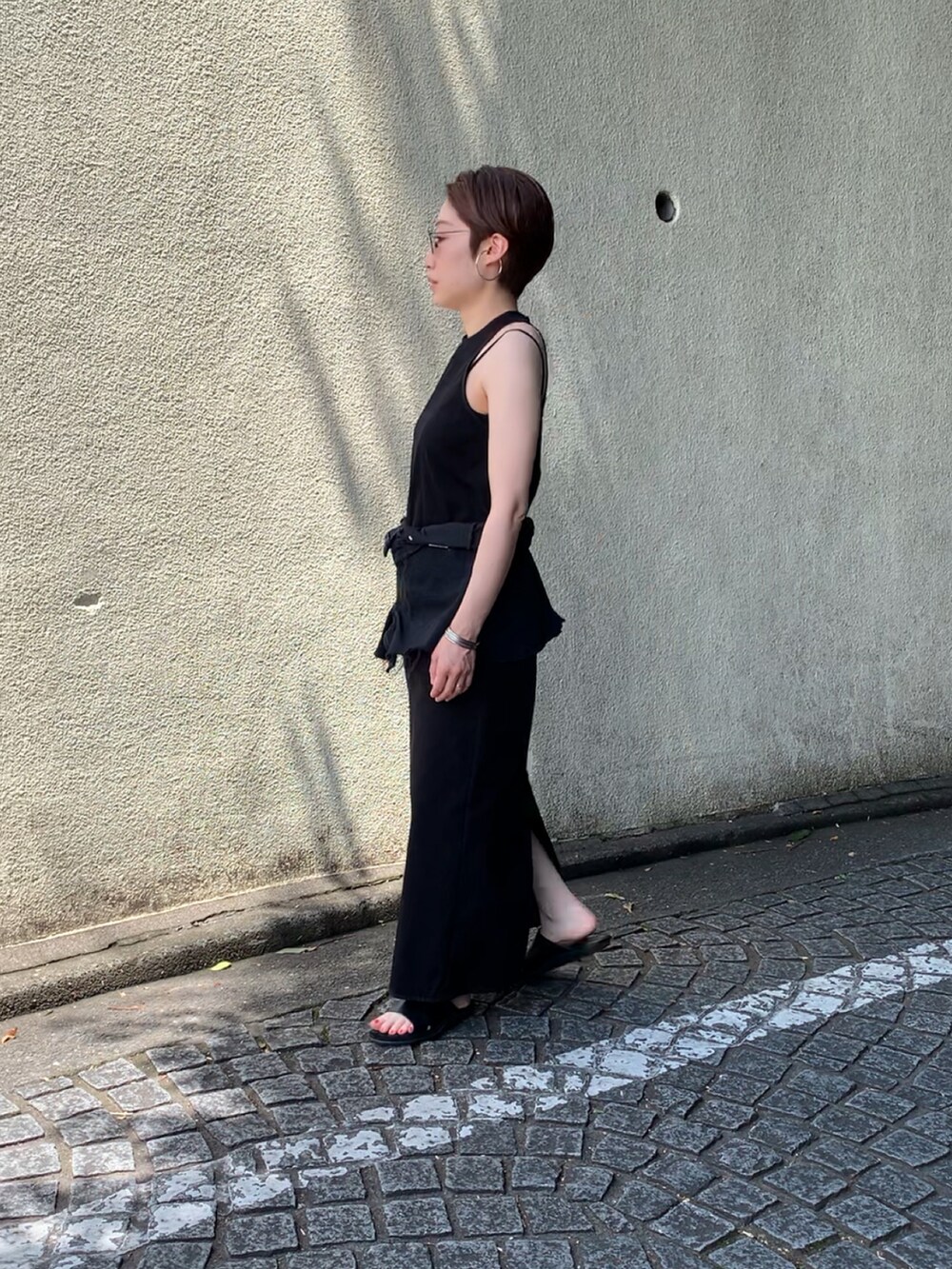 ブラック系のワンピース、ブラック系のパンツ、ブラック系のサンダルを着用したレディースの夏コーディネートの2枚目の写真