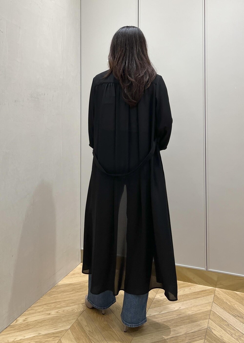 ブルー系のデニムパンツ、ブラック系のクラッチバッグを着用したレディースの春コーディネートの5枚目の写真