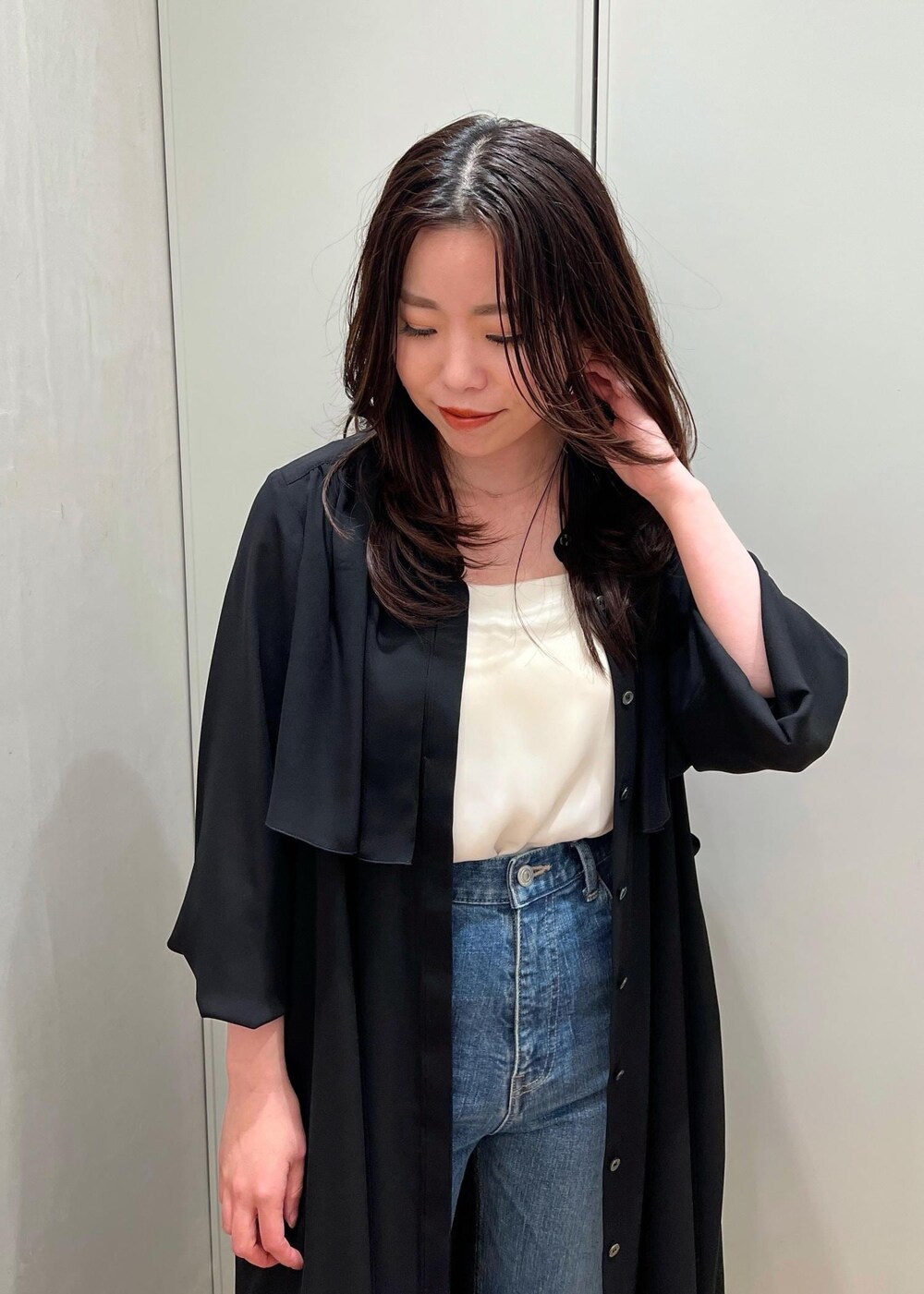 ブルー系のデニムパンツ、ブラック系のクラッチバッグを着用したレディースの春コーディネートの4枚目の写真