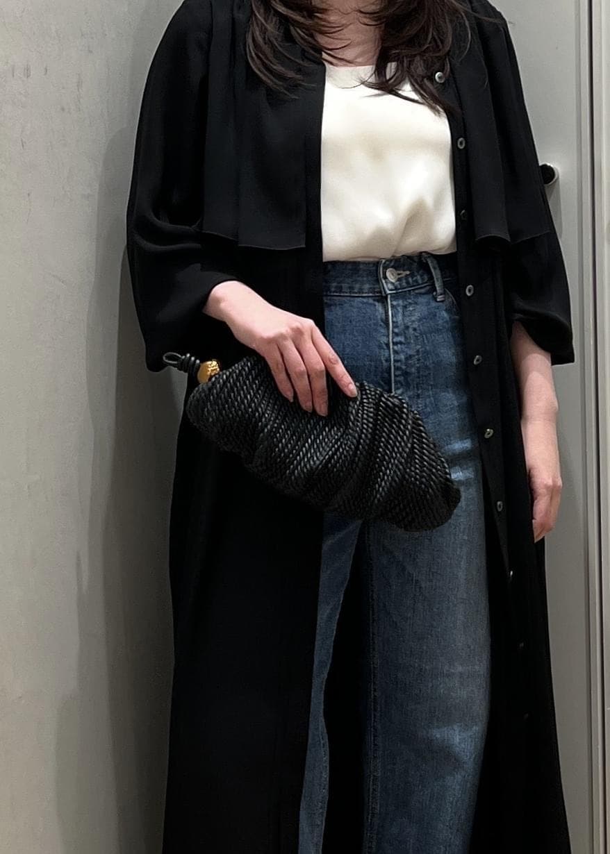 ブルー系のデニムパンツ、ブラック系のクラッチバッグを着用したレディースの春コーディネートの6枚目の写真