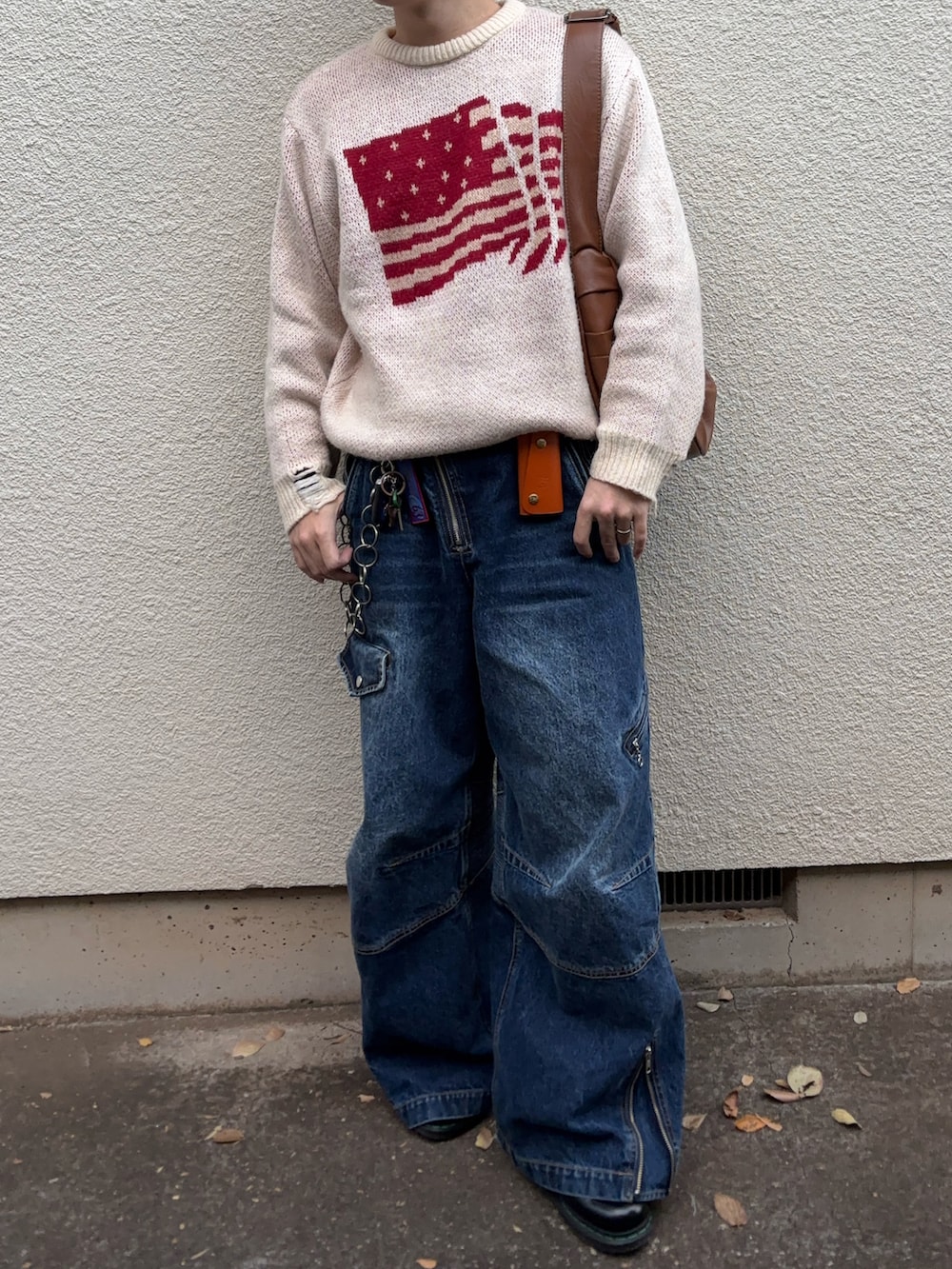 ホワイト系のニット/セーター、ブルー系のデニムパンツ、ブラック系のドレスシューズを着用したメンズの冬コーディネートの3枚目の写真