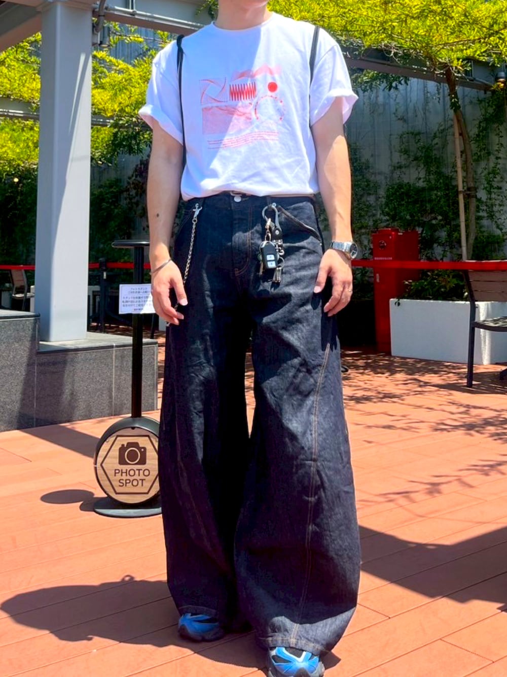 オレンジ系のTシャツ/カットソー、ブルー系のデニムパンツ、ブルー系のスニーカーを着用したメンズの夏コーディネートの2枚目の写真