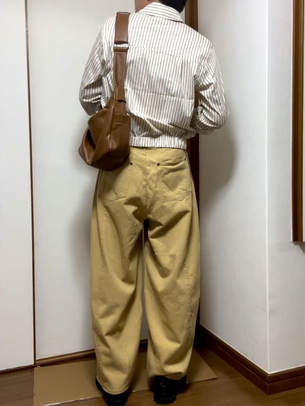 ベージュ系のブルゾン、ブラック系のスリッポン、ベージュ系のチノパンツを着用したメンズの秋コーディネートの2枚目の写真