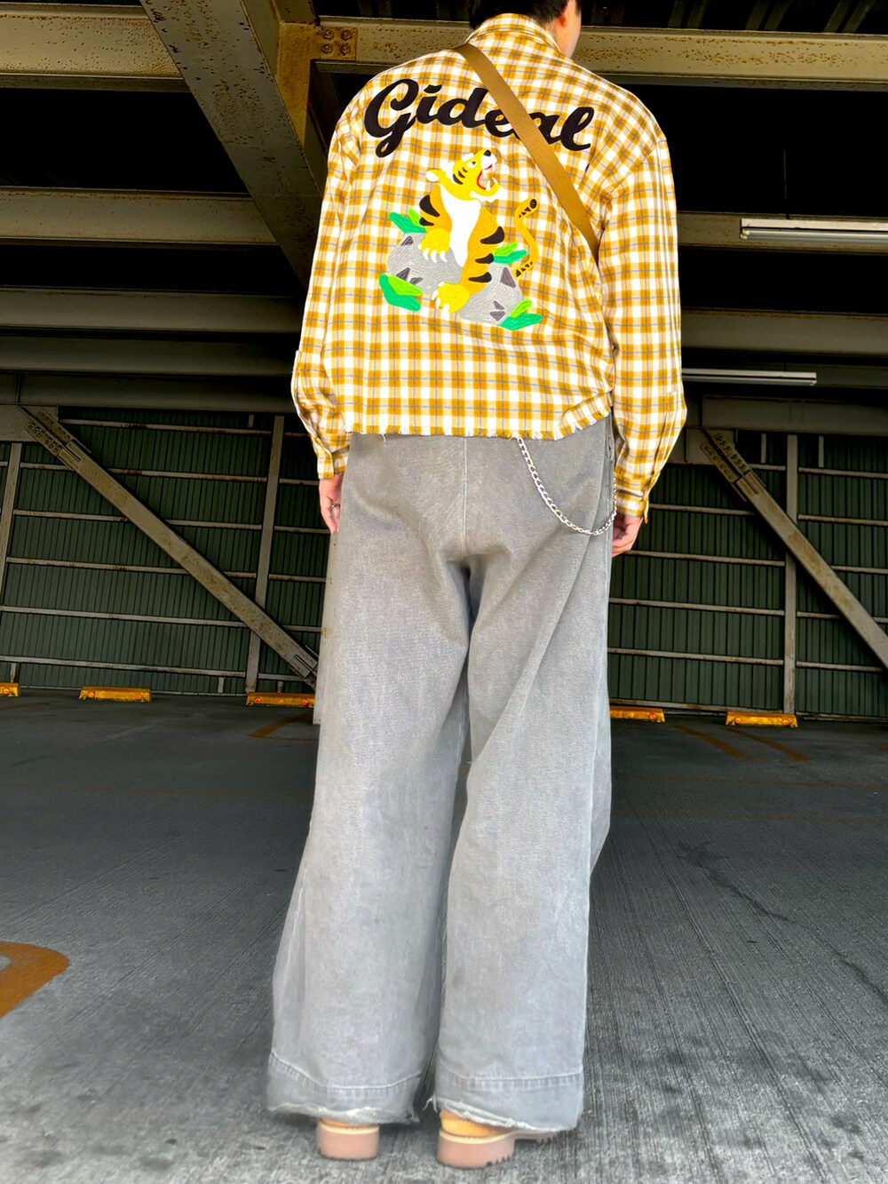 グレー系のデニムパンツ、ベージュ系のその他シューズ、イエロー系のキーケース/キーアクセサリーを着用したメンズの冬コーディネートの2枚目の写真