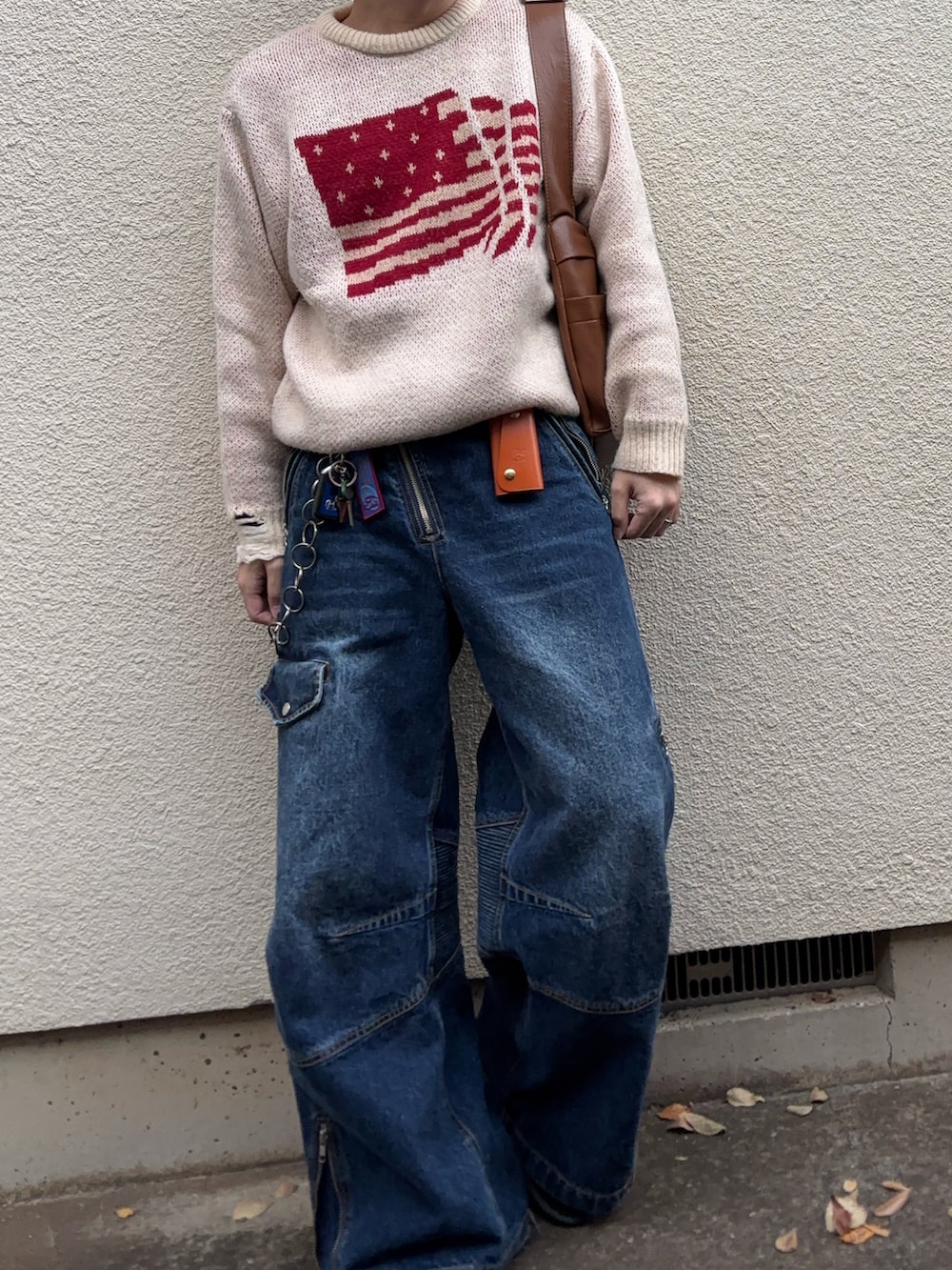 ホワイト系のニット/セーター、ブルー系のデニムパンツ、ブラック系のドレスシューズを着用したメンズの冬コーディネートの2枚目の写真