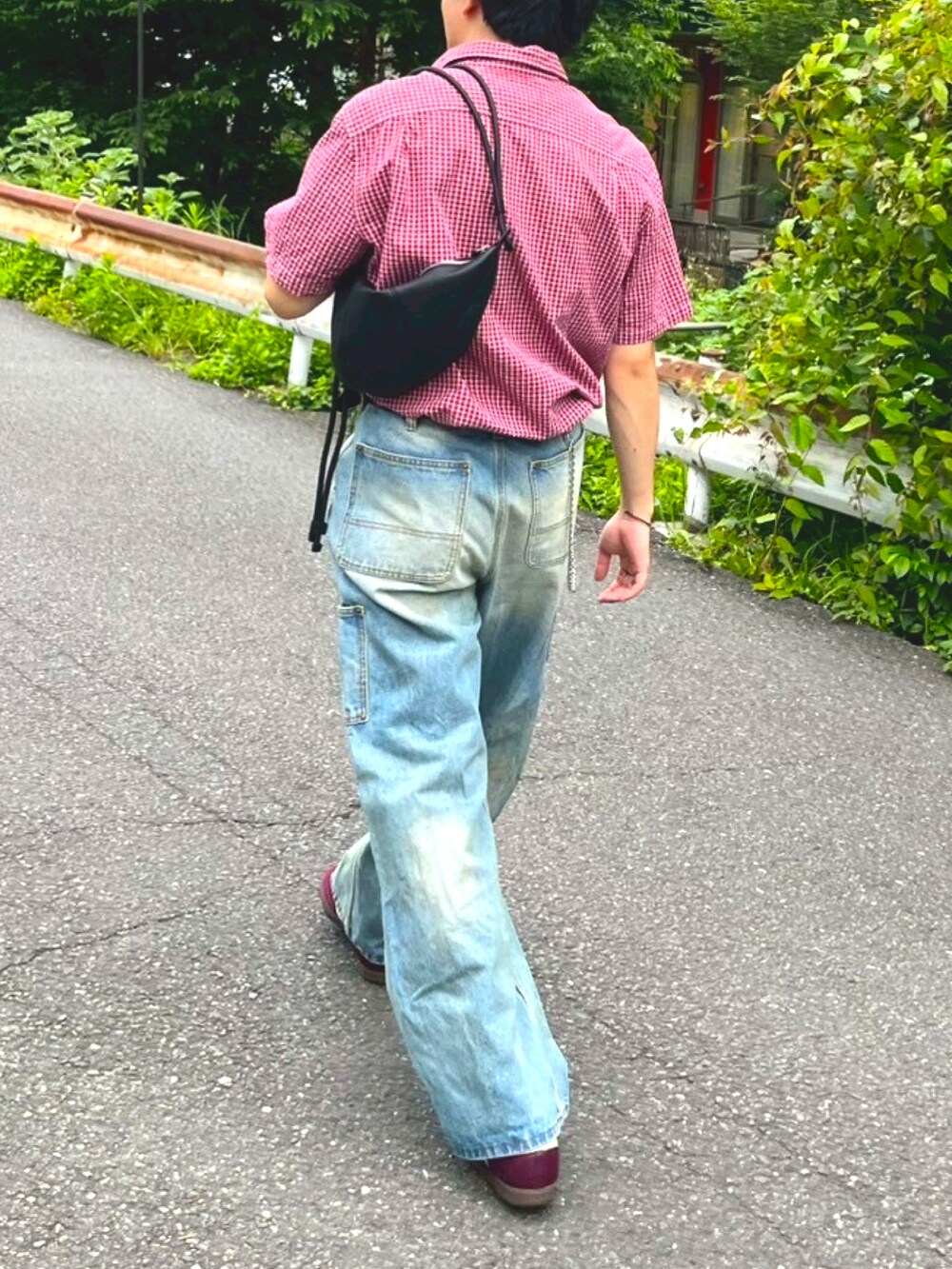 レッド系のトップス、ブルー系のデニムパンツ、レッド系のスニーカーを着用したメンズの春コーディネートの2枚目の写真