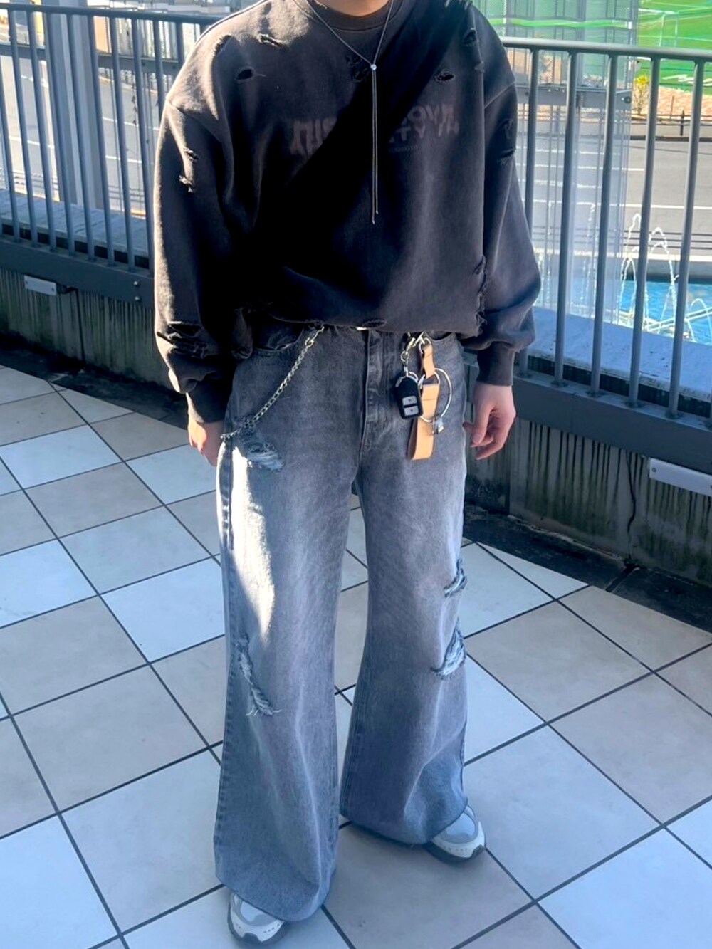 ブラック系のスウェット、ブラック系のデニムパンツ、ブラウン系のスニーカーを着用したメンズの冬コーディネートの2枚目の写真