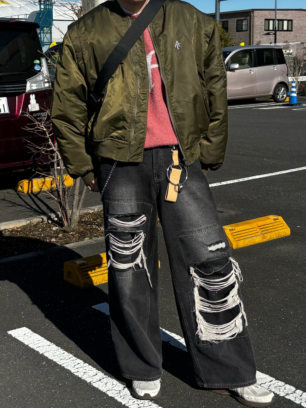 グリーン系のMA-1、ピンク系のニット/セーター、ブラウン系のスニーカーを着用したメンズの冬コーディネートの2枚目の写真