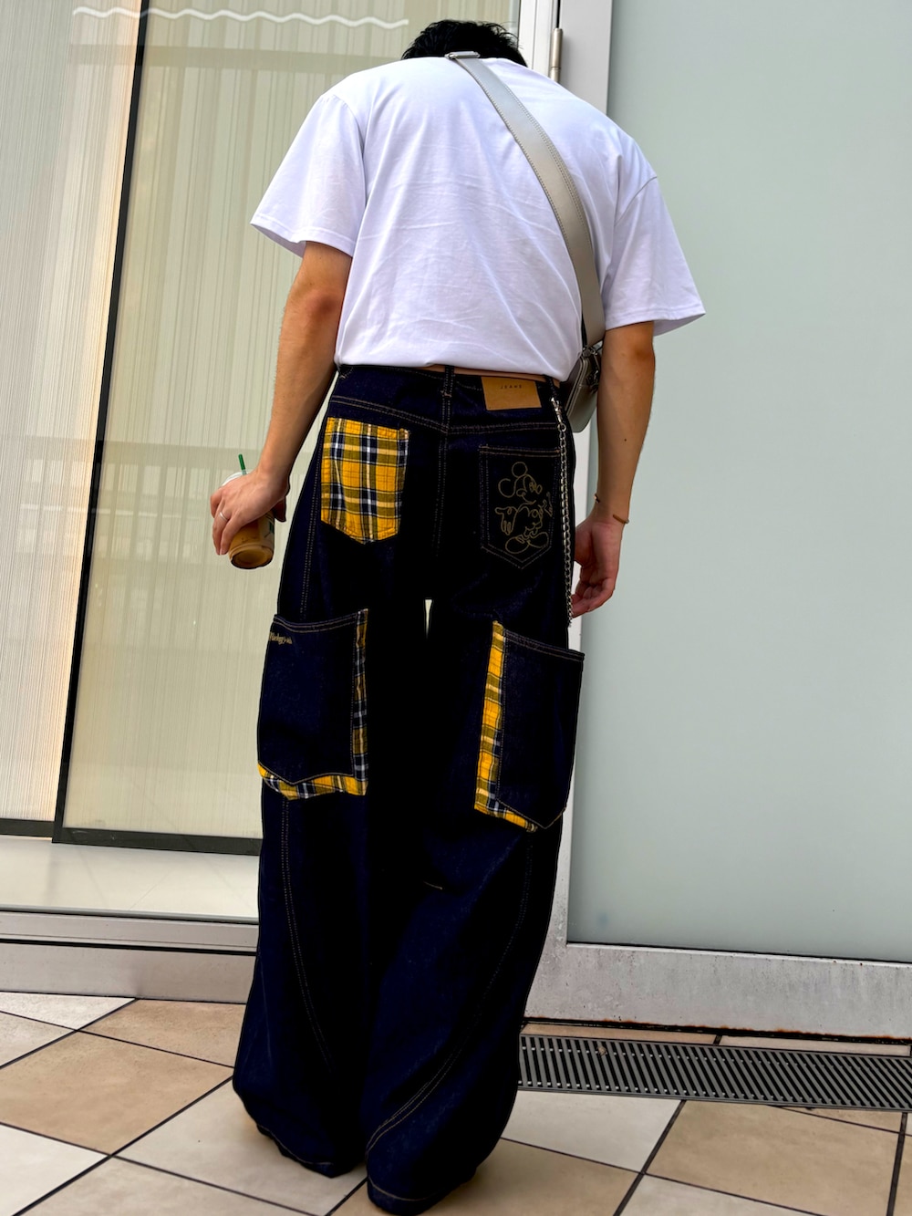 オレンジ系のTシャツ/カットソー、イエロー系のスニーカーを着用したメンズの夏コーディネートの2枚目の写真